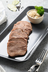 Sliced beef tongue with horseradish sauce. Close up. Vertical format.