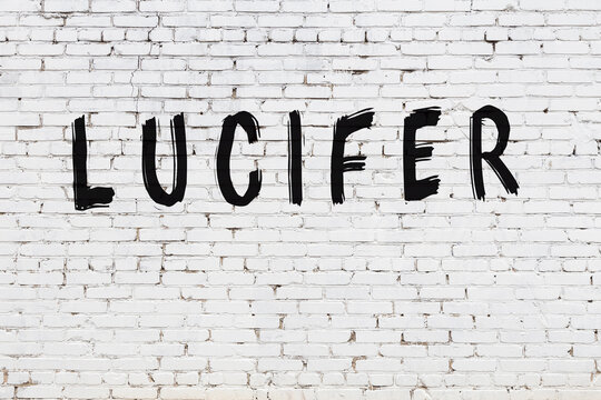 Inscription lucifer painted on white brick wall