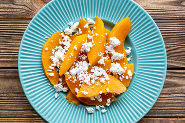 Roated pumpkin salad, close up. Tasty healthy autumn snack.