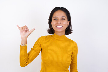 Young hispanic girl with short hair wearing casual yellow sweater isolated over white background...