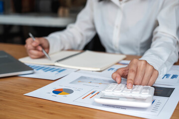 Business accounting, Businessman using calculator with budget document, computer laptop and in office, Savings, finances, and economy concept.