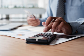 A businesswoman or an accountant uses a calculator to calculate prices. And customer proposals for...