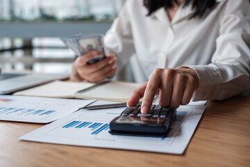 A businesswoman or an accountant uses a calculator to calculate prices. And customer proposals for future financial spending for balance and prosperity, using graphs to analyze