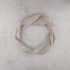 Fototapeta na wymiar Pure washed linen cloth on light grunge stone background. Natural washed linen fabric on stone tile surface with copy space