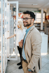 Young business man buying some drugs in a drugstore or pharmacy while attractive female pharmacist working something in background.