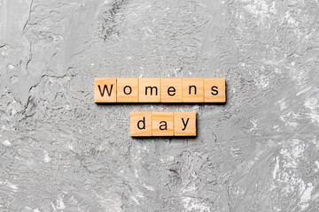 Womans day word written on wood block. Womans day text on cement table for your desing, concept