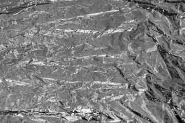 Texture of a thin crumpled sheet of foil. Crumpled foil background. Stock photo shiny foil. Silver...