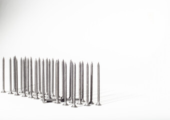 Metal nails on a white background, standing vertically. obstruction of thoughts