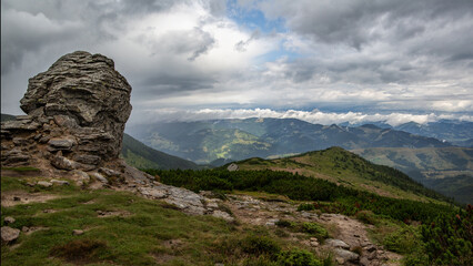 Obraz premium Beautiful gloomy mountain landscape after the rain. Rocks in the foreground and clouds in the background