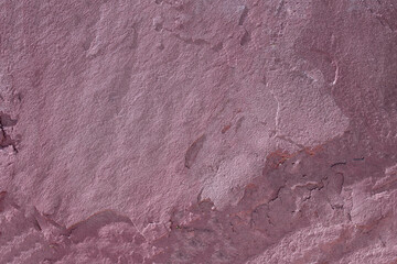 Bright pink slate texture background panorama. Rustic stone is weathered and cracked by time and weather on the exterior of a rural home. Garden design. Copy space.