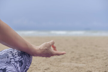 Closeup hand with lotus pose yoga on the beach