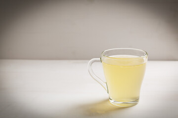 Homemade bone broth with leek in glass cup