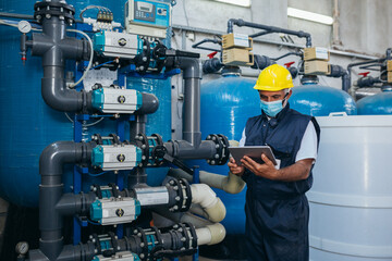 industry worker checking chemical water treatment equipment