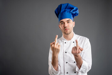 Young male dressed in a white chef suit showing double fuck you
