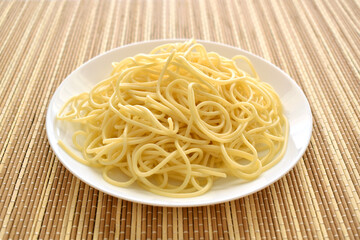 Cooked spaghetti on a white plate. 