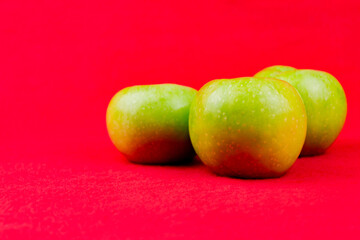 Green apples on a red background