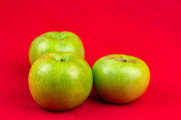 Green apples on a red background