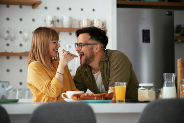 Young couple making delicious food at home. Loving couple enjoying in the kitchen..