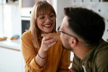 Young couple making delicious food at home. Loving couple enjoying in the kitchen..