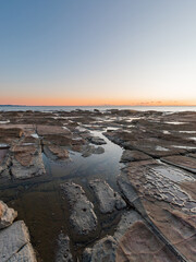 Rocky seascape with sunrise sky.