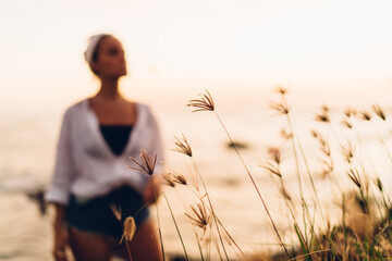 Unrecognizable woman standing in dry grass