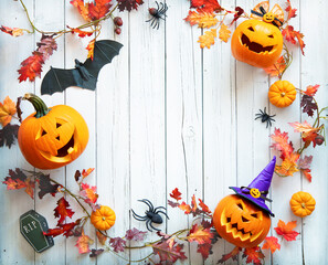 Halloween pumpkins and decorations on light wooden background