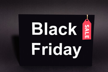 placard with black friday lettering and sale tag on dark background
