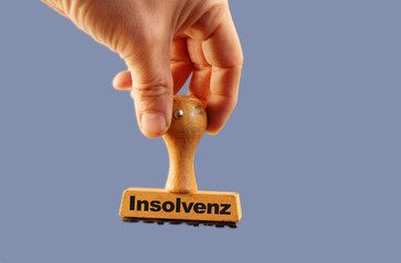 Insolvenz in engl bankcruptcy rubber stamp hand with blue background