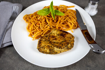 escalope  de poulet et spaghetti à la tomate dans une assiette