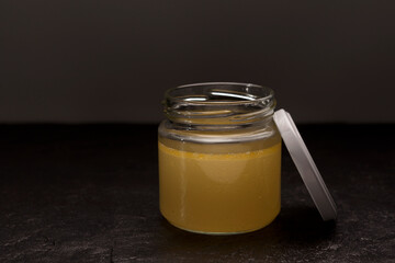 Bone broth with natural collagen in transparent jar with lid. Healthy food. Close-up, selective focus, copy space