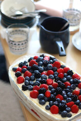 Tiramisu cake, decorated with berries, served on a table. Selective focus.
