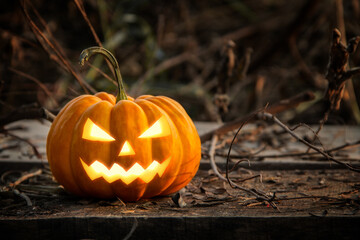 Jack-o'-lantern glowing halloween pumpkin head have yellow light on the old wood floor at abandoned...