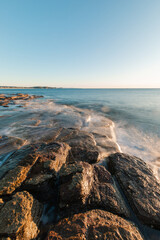 Water flowing around the rocky coastline.