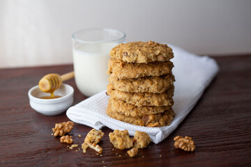 oatmeal cookies with walnuts lie in a stack on a kitchen towel on a wooden table