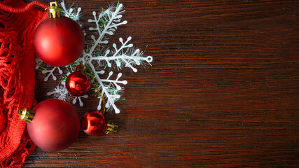  Red Christmas toys in a string bag on a brown wood background, with snowflake