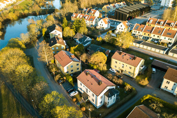 Aerial view of residential houses with red roofs and streets with parked cars in rural town area....