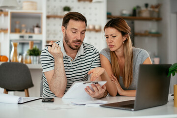 Husband and wife preparing bills to pay. Young couple having financial problems.