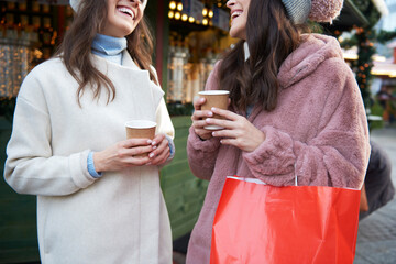 Two friends chatting and drinking wine mulled on Christmas Market