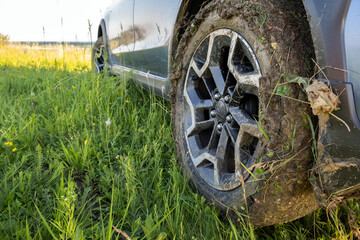 Close up of dirty off road car wheels with dirty tires covered with yellow mud.