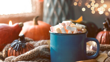 Autumn background with dry leaves, blue cup of coffee. Knitted background, pumpkins, October, November. Autumnal atmosphere. Autumn season.