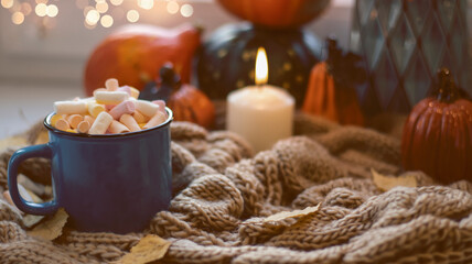 Fototapeta na wymiar Autumn background with dry leaves, blue cup of coffee. Knitted background, pumpkins, October, November. Autumnal atmosphere. Autumn season.