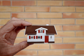 petite maison entre les doigts d'un homme