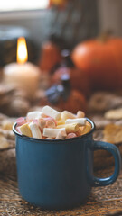 Autumn background with dry leaves, blue cup of coffee. Knitted background, pumpkins, October, November. Autumnal atmosphere. Autumn season.