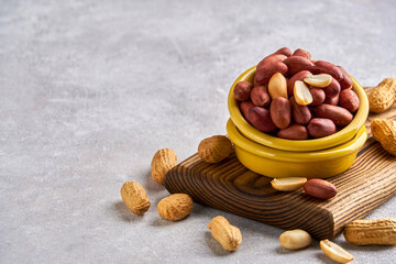 Roasted peeled peanuts in ceramic bowl , closeup, copy space