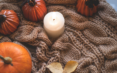 Autumn background with dry leaves, blue cup of coffee. Knitted background, pumpkins, October, November. Autumnal atmosphere. Autumn season.