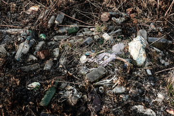 bottles and other garbage in the burnt grass