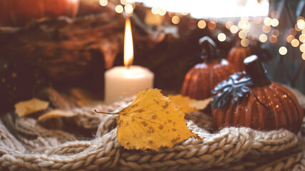 Autumn background with dry leaves, blue cup of coffee. Knitted background, pumpkins, October, November. Autumnal atmosphere. Autumn season.