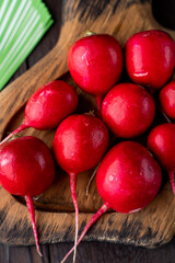 Bunch of wet fresh crunchy radish, close up on wooden background