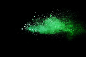 Green powder explosion on black background.