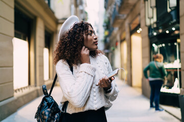 Fototapeta premium Stylish black woman listening to music on street